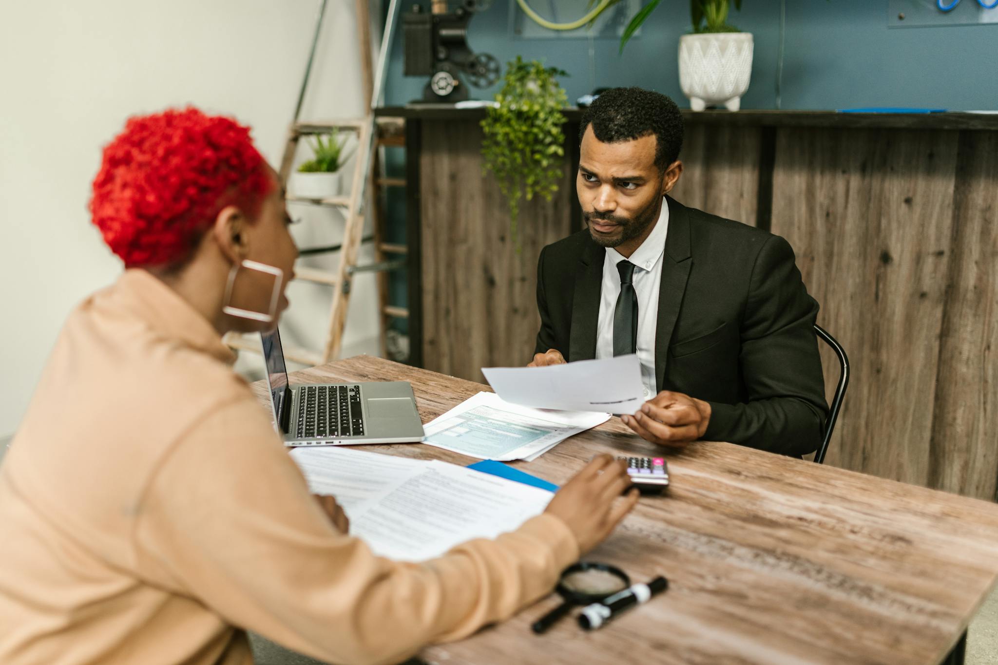 A discussion between two professionals focusing on financial documents in a modern office setting.